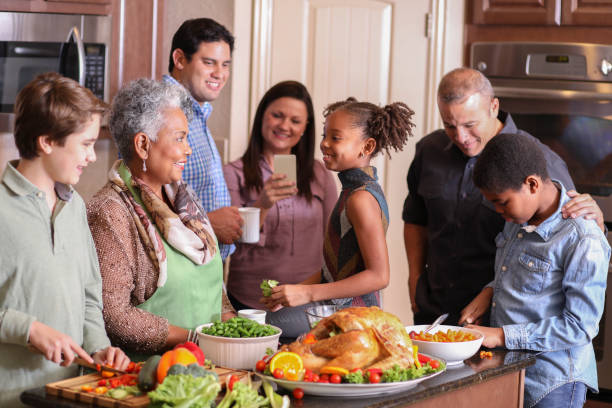 istock Diverse family in home kitchen cooking Thanksgiving dinner. 1056424612