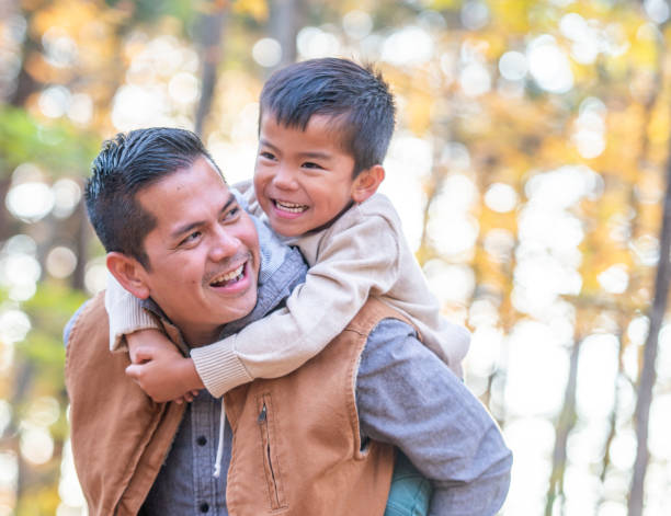 istock Dad gives his son a piggyback in a forest 1056424756