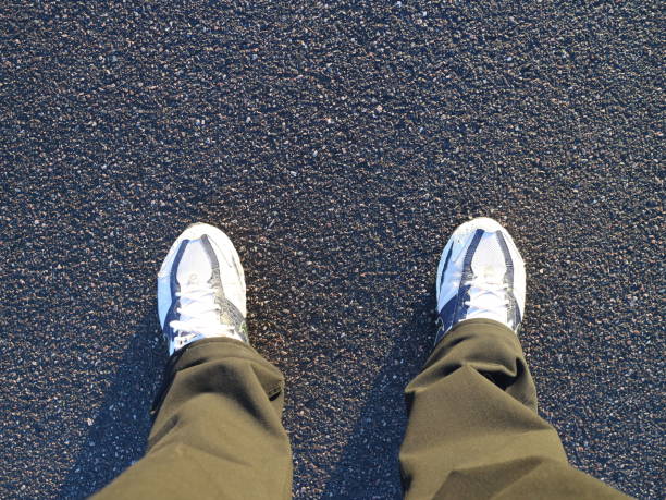 istock Black trousers and sneakers on the asphalt 1056425052