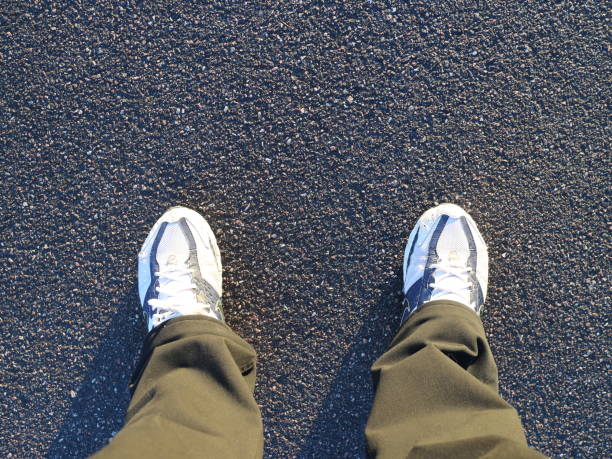 istock Black trousers and sneakers on the asphalt 1056425128