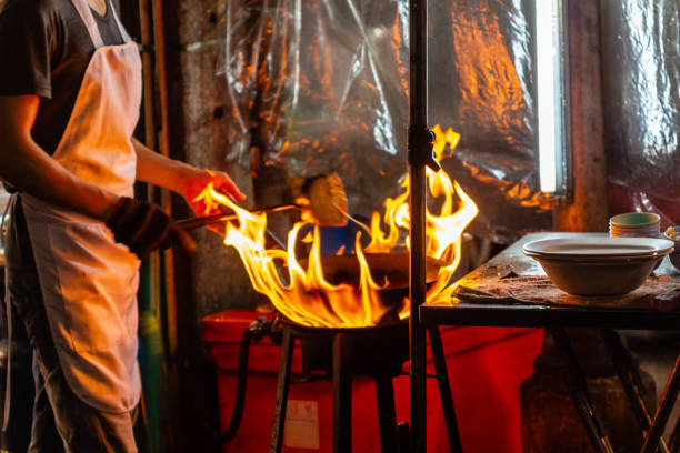 istock Chef cooking with flame in a pan at night 1056425422