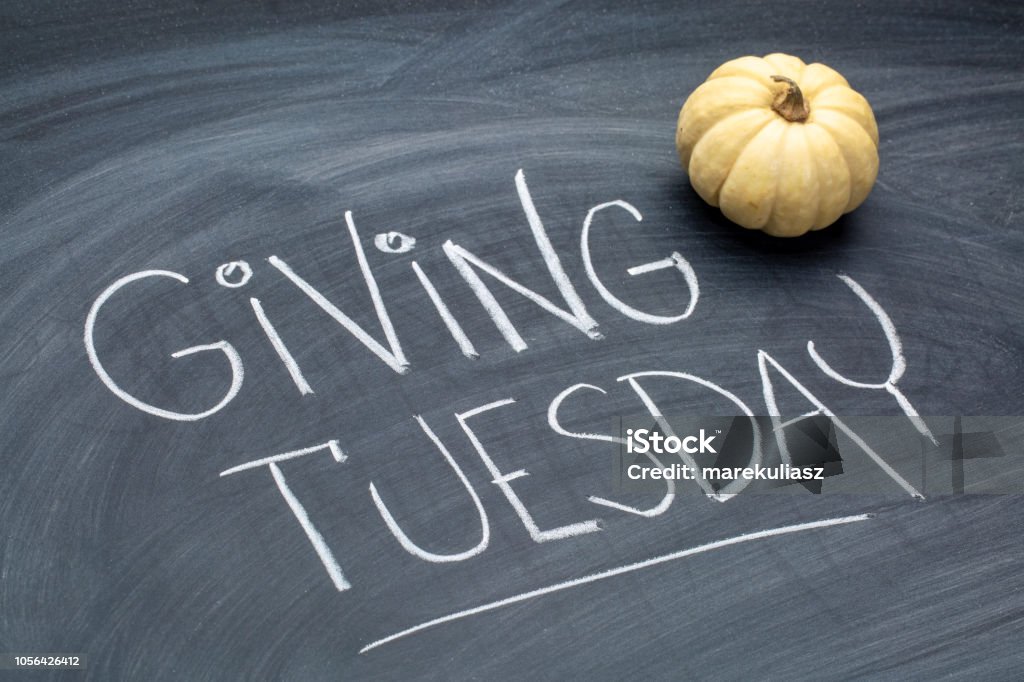 Giving Tuesday blackboard sign Giving Tuesday  - white chalk handwriting on a  blackboard  with ornamental gourd Giving Stock Photo