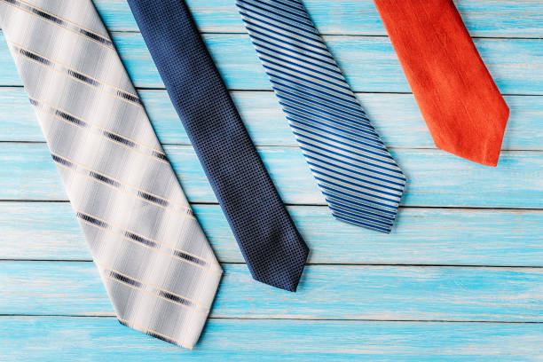 istock four colored ties in row on wooden blue background 1056429808