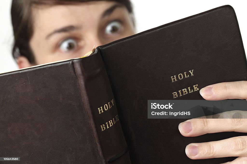 Eye-opener Young woman reading the Bible with surprised look Bible Stock Photo