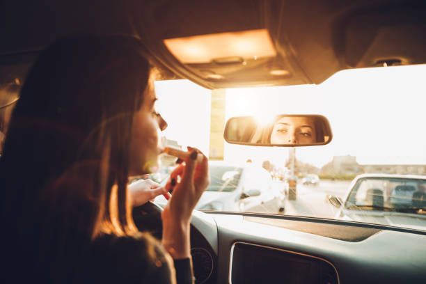 istock Businesswoman fixing make-up in rear view mirror 1056439774