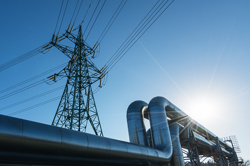 Industrial pipelines on pipe-bridge against blue sky