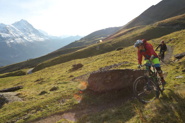 istock Mountain bikers ride on trail in the Alps 1056440758