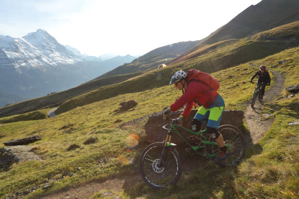 istock Mountain bikers ride on trail in the Alps 1056440760