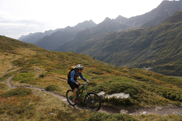 istock Mountain bikers on trail in the Alps 1056440900