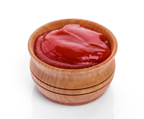 istock Ketchup in wooden bowl isolated on white background 1056445010