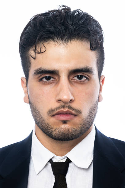 Serious young man headshot Serious hispanic or middle eastern young man looking at the camera on white background headshot iranian ethnicity stock pictures, royalty-free photos & images