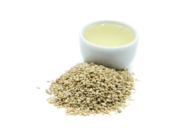 istock Sesame oil and sesame seeds isolated on white background 1056448578