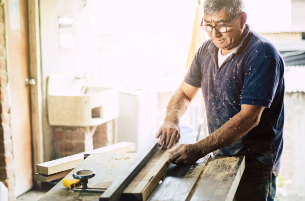 istock Carpenter cutting wooden board at his workshop 1056449318