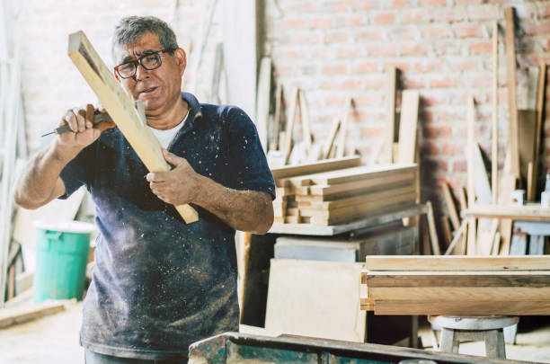 istock Senior carpenter checking and measures wooden plank. 1056449776
