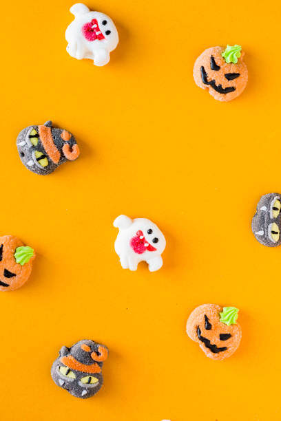 istock Halloween candies arranged in an alternating pattern on an colored background 1056451492