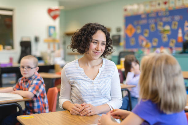istock A first grade teacher talking with one of her students in the classroom 1056453154