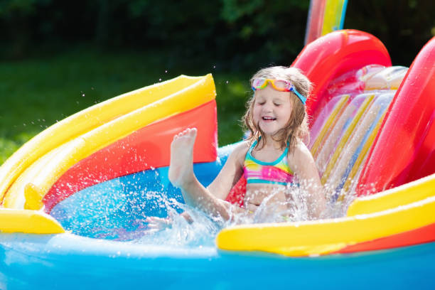 istock Child in garden swimming pool with slide 1056453454