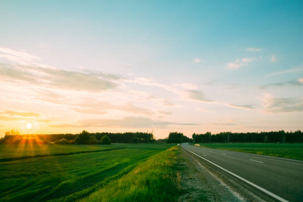 istock Sunset on a background of green fields and roads 1056463028