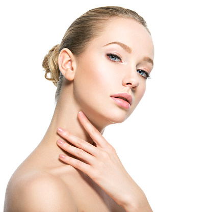 Beautiful face of young caucasian woman with perfect health skin  - isolated on white.  Skin care concept. Female touches the neck