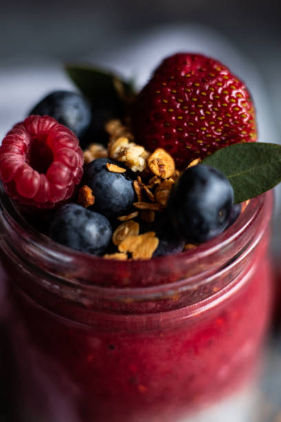 Close-up fresh smoothie with berries and granola.