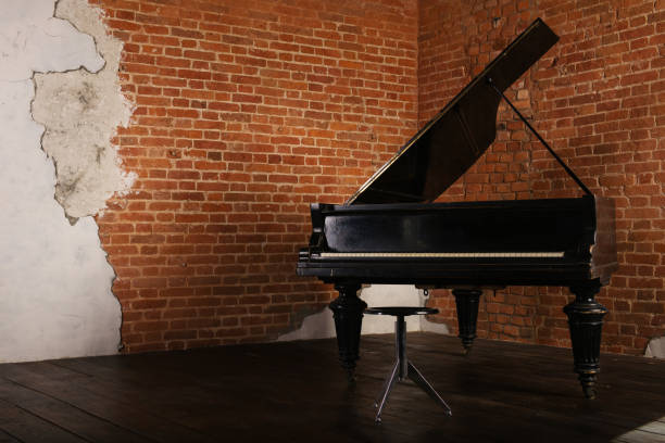 istock Grand piano with raised lid near brick wall 1056469566