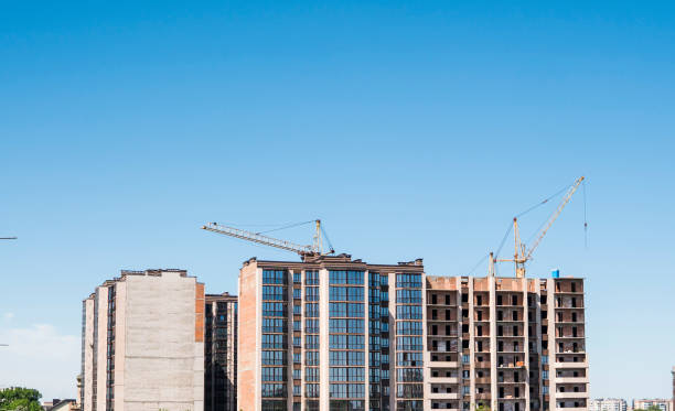 istock Construction of a high-rise building with a crane. Building construction using formwork. Cranes and buildings against the blue sky. 1056469834