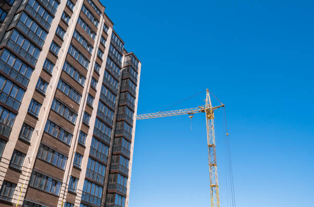 istock Construction of a high-rise building with a crane. Building construction using formwork. Cranes and buildings against the blue sky. 1056469922