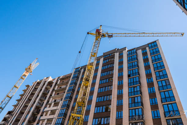 istock Construction of a high-rise building with a crane. Building construction using formwork. Cranes and buildings against the blue sky. 1056469938
