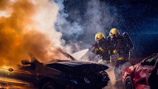 istock Two firefighter extinguishing a burning car after a traffic accident 1056471296
