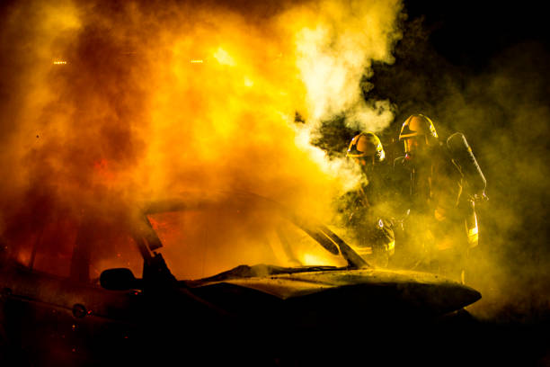 istock Two firefigthers examining a burning car to assess their fire extinguishing strategy 1056471378
