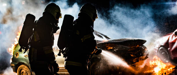 istock Rear view of two firefighters extinguishing a burning vehicle 1056471554