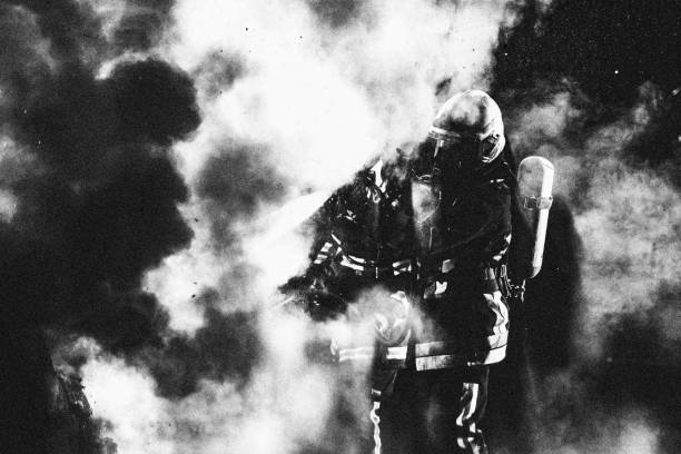 istock Black and white photo of firefighters walking through smoke 1056471638