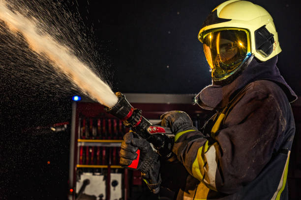 istock Close-up of a firefighter operating a spraying fire hose 1056471682