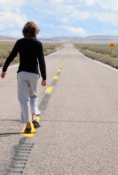 istock boy walking on road to horizon 1056472954