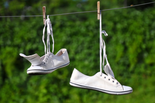 White sneakers are hanging on a clothesline