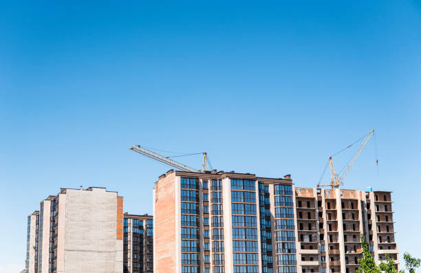 istock Construction of a high-rise building with a crane. Building construction using formwork. Cranes and buildings against the blue sky. 1056483764