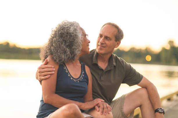 istock Interracial senior couple sit on the dock on a summer morning 1056483822