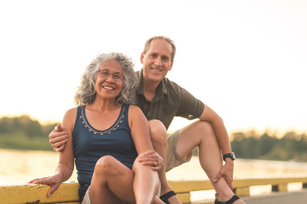 istock Interracial senior couple sit on the dock on a summer morning 1056483850