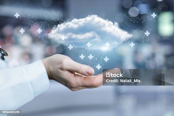 Una Nuvola Circondata Da Segni Medici Che Volano Sopra La Mano Di Un Medico - Fotografie stock e altre immagini di Cloud computing