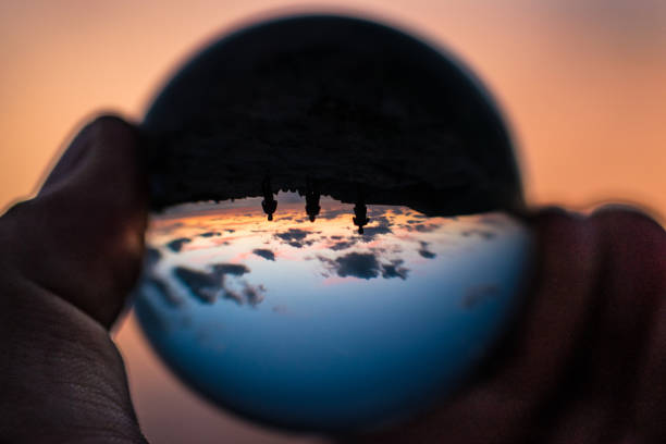 Sunset with a difference three people in Globe Sunset with a difference three people in Globe at sunset in Golden bay Malta. copy space. upside down. silhouette of persons. women hand holding crystal ball. Peace, love , tranquility, sun down. maltese silhouette stock pictures, royalty-free photos & images