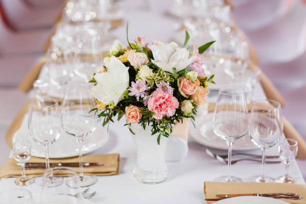 istock Table at a luxury wedding reception. Beautiful flowers on the table. Serving dishes, glass glasses, waiters work, 1056491136