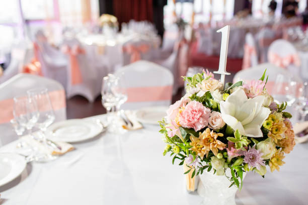 istock Round table at a luxury wedding reception. Beautiful flowers on the table. Serving dishes, glass glasses, waiters work, 1056494376