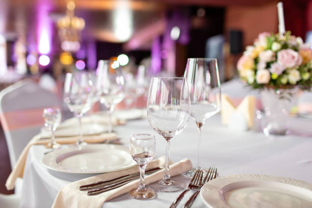 istock Round table at a luxury wedding reception. Beautiful flowers on the table. Serving dishes, glass glasses, waiters work, 1056494906