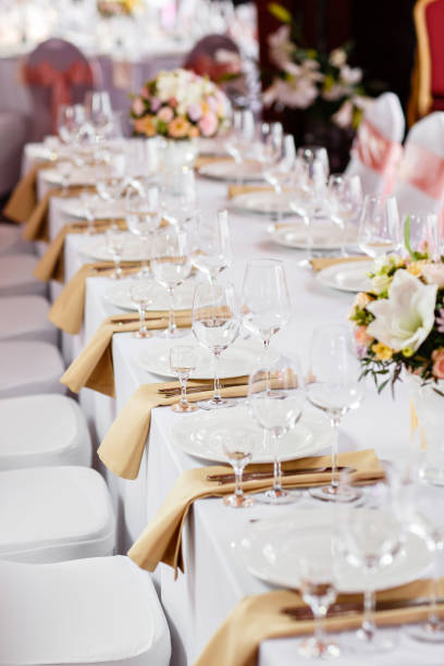 istock Table at a luxury wedding reception. Beautiful flowers on the table. Serving dishes, glass glasses, waiters work, 1056495200