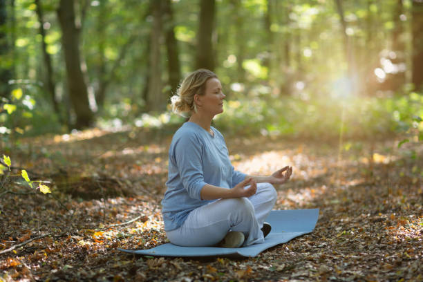 istock Healthy pregnancy: blond woman exercising Yoga Outdoors in forest 1056497230