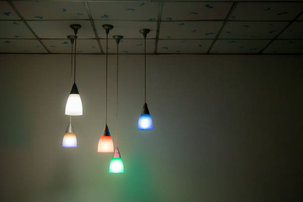 istock Colorful lighting lanterns hang  on the ceiling in the dark room. image for background, wallpaper, object in interiior and copy space. 1056497652