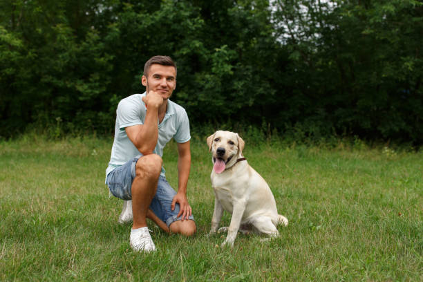 istock Young man with his friend - dog labrador 1056497872