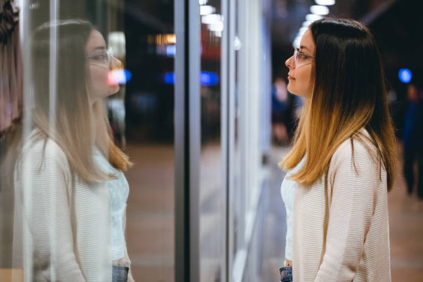 istock Young woman window shopping at night 1056499858