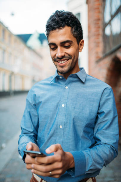 istock Brazilian businessman using smart phone to respond to messages and e-mails 1056501862
