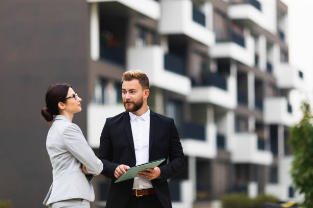 Real estate agent with a client A real estate agent on a meeting with a businesswoman real estate agent male stock pictures, royalty-free photos & images